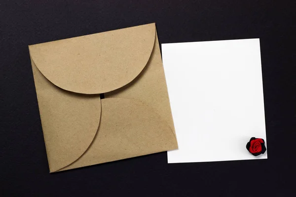 Vintage square envelope and a sheet of paper on a black background — Stock Photo, Image