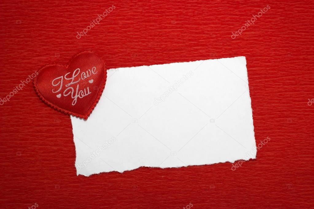 Red heart with an inscription and a white sheet of paper