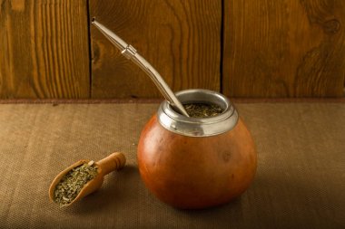 Calabash yerba dostum ve bir tahta kaşık bir ağaç arka planı