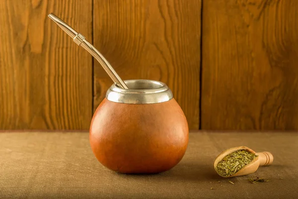 Calabash yerba dostum ve bir tahta kaşık bir ağaç arka planı — Stok fotoğraf