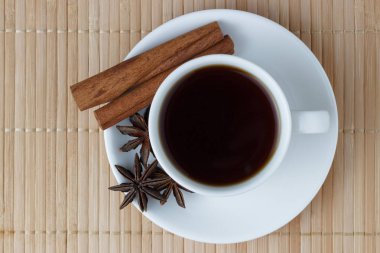 Tarçın ve anason ile beyaz bir fincan sıcak kahve