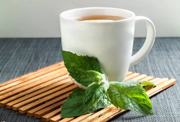 Hot tea with mint on a bamboo stand — Stock Photo, Image