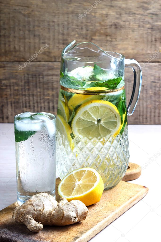Fruit water with lemon, cucumber and mint in glass pitcher.