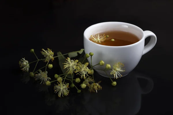 Чай у білій чашці з липою на чорному тлі з відображенням — стокове фото