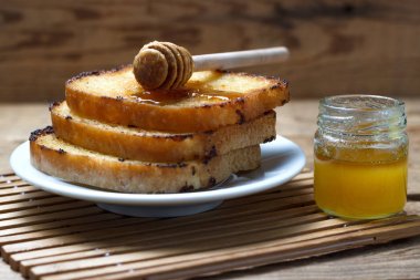 Ahşap arka plan üzerinde bal ile üç kızarmış tost