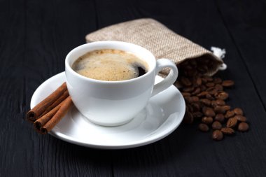 Kahve tarçın siyah bir arka plan ve bir çanta dolusu kahve çekirdekleri ile