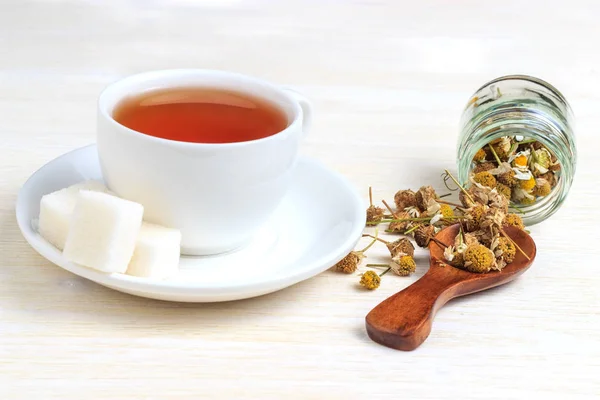 Tee in einer Tasse mit einem Zuckerwürfel und einem Holzlöffel — Stockfoto