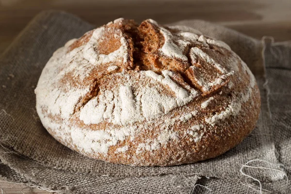 Bir çanta ve bir ahşap arka plan üzerinde yuvarlak ekmek yalan — Stok fotoğraf