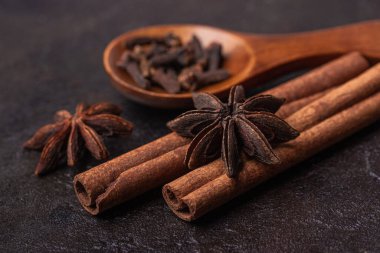 Anason, tarçın çubukları ve karanfiller tahta kaşıkta, makro