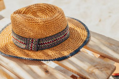 Denizde bekletin. Hasır şapka ahşap şezlong üzerinde. güneşli gün