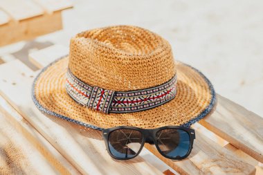 Güneş gözlüğü ve ahşap bir şezlonga saman kadın şapkasını lounge. Sümer tatil. 