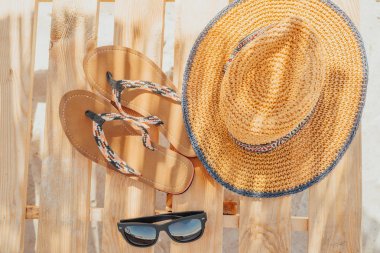 Kadın hasır şapka ve güneş gözlüğü. Üstten Görünüm, plaj terlikleri. Yaz konsepti