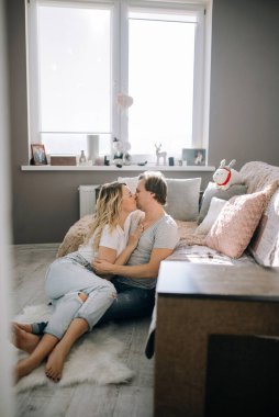 Kanepenin yanında bir çift öpüşüyor.