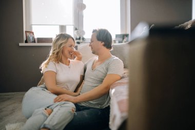 Genç çift kanepenin yanında yerde eğleniyor.