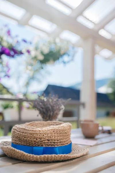 Yazın kır evindeki ahşap bir masada hasır bir şapka yatıyor.