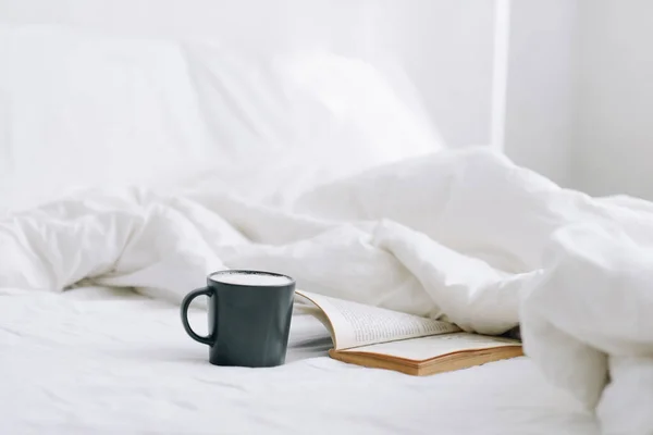 Bir fincan kahve ve açık bir kitap.