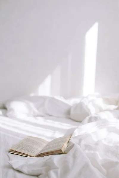 Yatakta kitabı aç. Dikey fotoğraf 