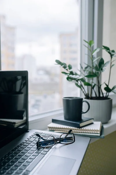 Evdeki işyerinde, pencere eşiğinde. Dikey fotoğraf.