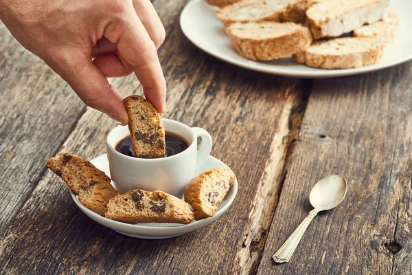 Hand dip cantucci in the coffee. Typical Italian cookie — Stock Photo, Image