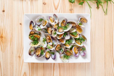 Beyaz kare tabak üzerinde buğulanmış midye