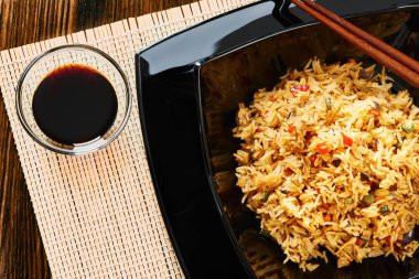 Pirinç sebze siyah kare tabak, yemek çubukları, soya sos ile