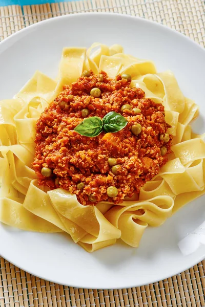 Macarrão tagliatelle com molho bolonhês em prato branco — Fotografia de Stock