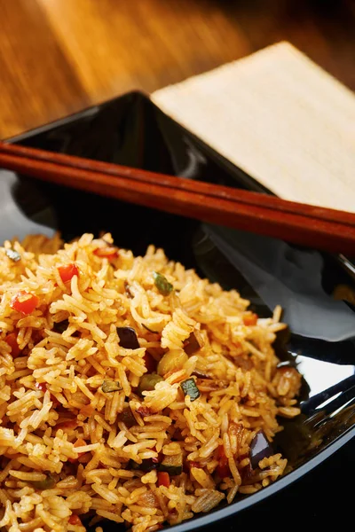 stock image Rice with vegetables on black square dish close up - text space on the top