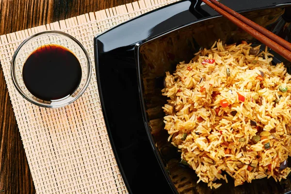 Pirinç sebze siyah kare tabak, yemek çubukları, soya sos ile