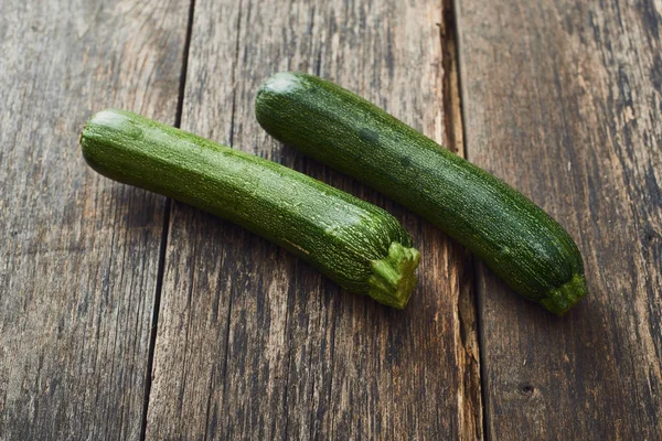 Zucchini on old wooden table — Stock Photo, Image