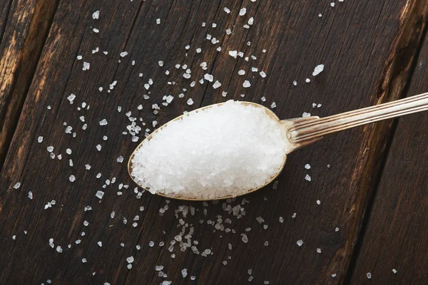 Sól morska w łyżką na drewnianym stole — Zdjęcie stockowe