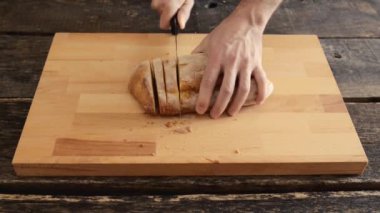 Erkek el ahşap kesme tahtası üzerinde ekmek dilimleme