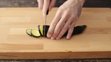 el erkek kabak ahşap kesme tahtası üzerinde kesmek.