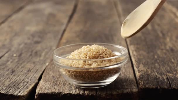 Рис в стеклянной миске с деревянной ложкой — стоковое видео