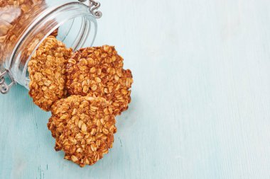 Yulaf ezmesi muz çerezlerini bir kavanoz mavi masada - metin alanı sağdaki