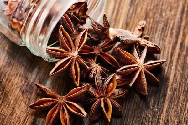 Yakın çekim yıldız anason cam kavanozdan ahşap masanın üzerine çıkar