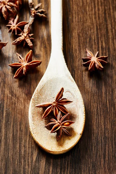 Star anise in wooden spoon on wooden table