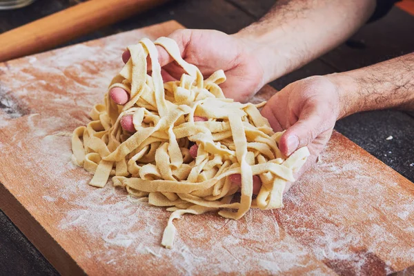 Male hands taking handmade pasta
