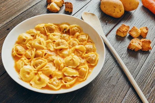 Supă Tortellini în farfurie albă pe masă de lemn — Fotografie, imagine de stoc