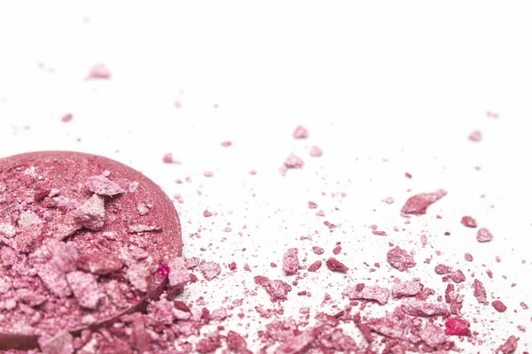 Crushed pink blush on white background.