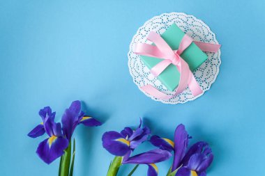 hediye beyaz peçete ve mavi arka plan üzerinde üç süsen