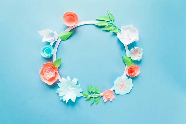 Cornice rotonda con fiori di carta a colori sullo sfondo blu. Piatto. Concetto natura — Foto Stock