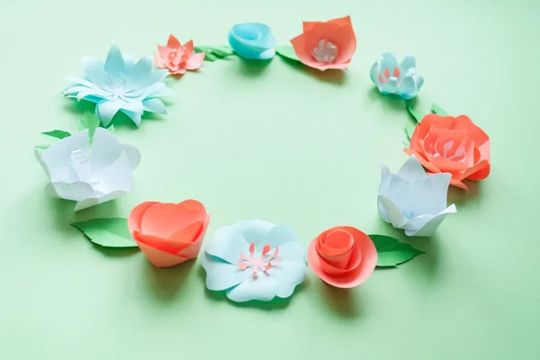 Cornice rotonda con fiori di carta a colori sullo sfondo verde. Piatto. Concetto natura — Foto Stock