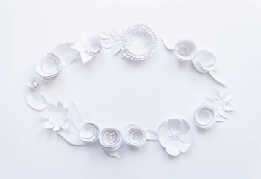 Beyaz arka plan üzerinde beyaz kağıt çiçeklerle oval çerçeve.