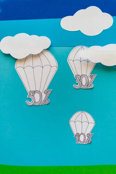 Concept van moderne verkoop. Hemel, wolken, parachutes, kortingen, gesneden uit papier. — Stockfoto