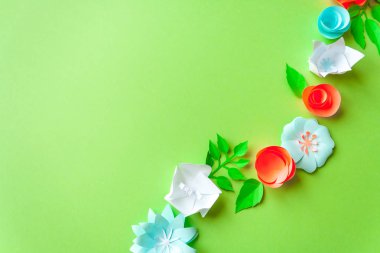 yeşil arka plan üzerinde renkli kağıt çiçekli çerçeve. Düz yatıyordu. Doğa kavramı