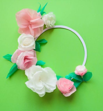 Yuvarlak kare yeşil arka plan üzerinde renkli kağıt çiçeklerle. Düz yatıyordu. Doğa kavramı