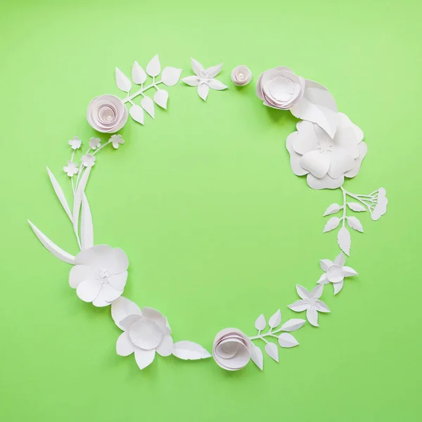 Cornice rotonda con fiori di carta bianca su sfondo verde . — Foto Stock