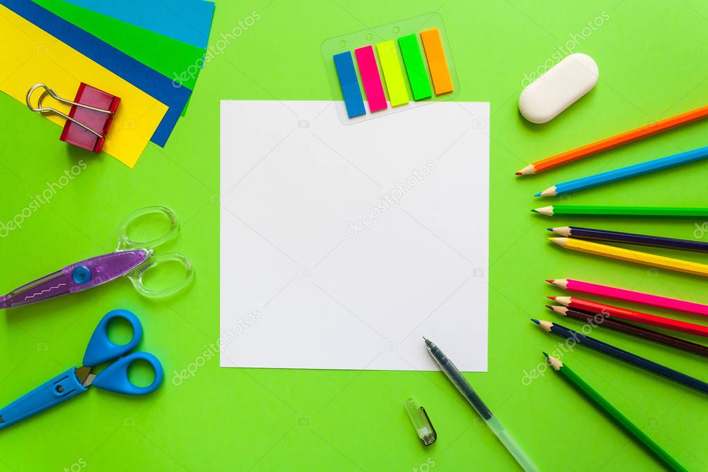 square frame with stationery flat lay on green background