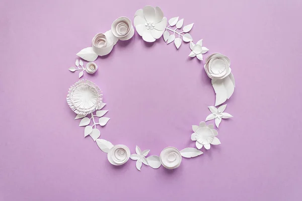 round frame with paper flowers on the purple background