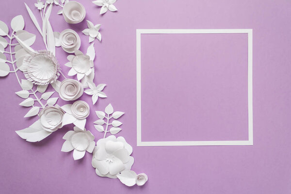 square frame with white paper flowers on violet background. Cut from paper.